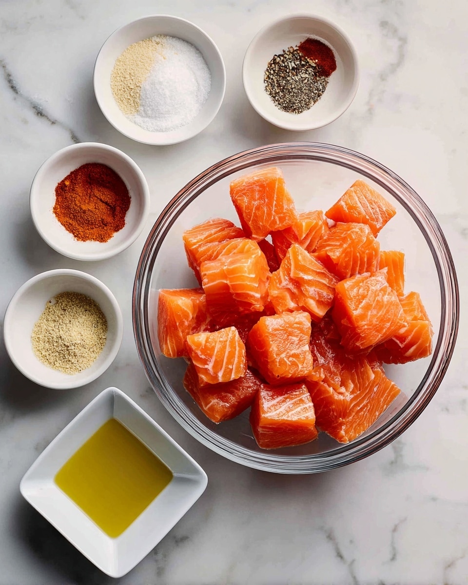 A clear glass bowl in the center filled with many pieces of bright orange salmon with white fat lines, each piece roughly cube-shaped. Around the top left side are five small white bowls, each holding different spices: one bowl with fine off-white onion powder, another with dark orange cayenne powder, a bowl with a mix of white salt and black pepper, one with dark red smoked paprika, and another with pale yellow garlic powder. Below these bowls and to the left is a small white square dish filled with light yellow olive oil. All items are placed on a white marbled surface with soft gray veining. photo taken with an iphone --ar 4:5 --v 7