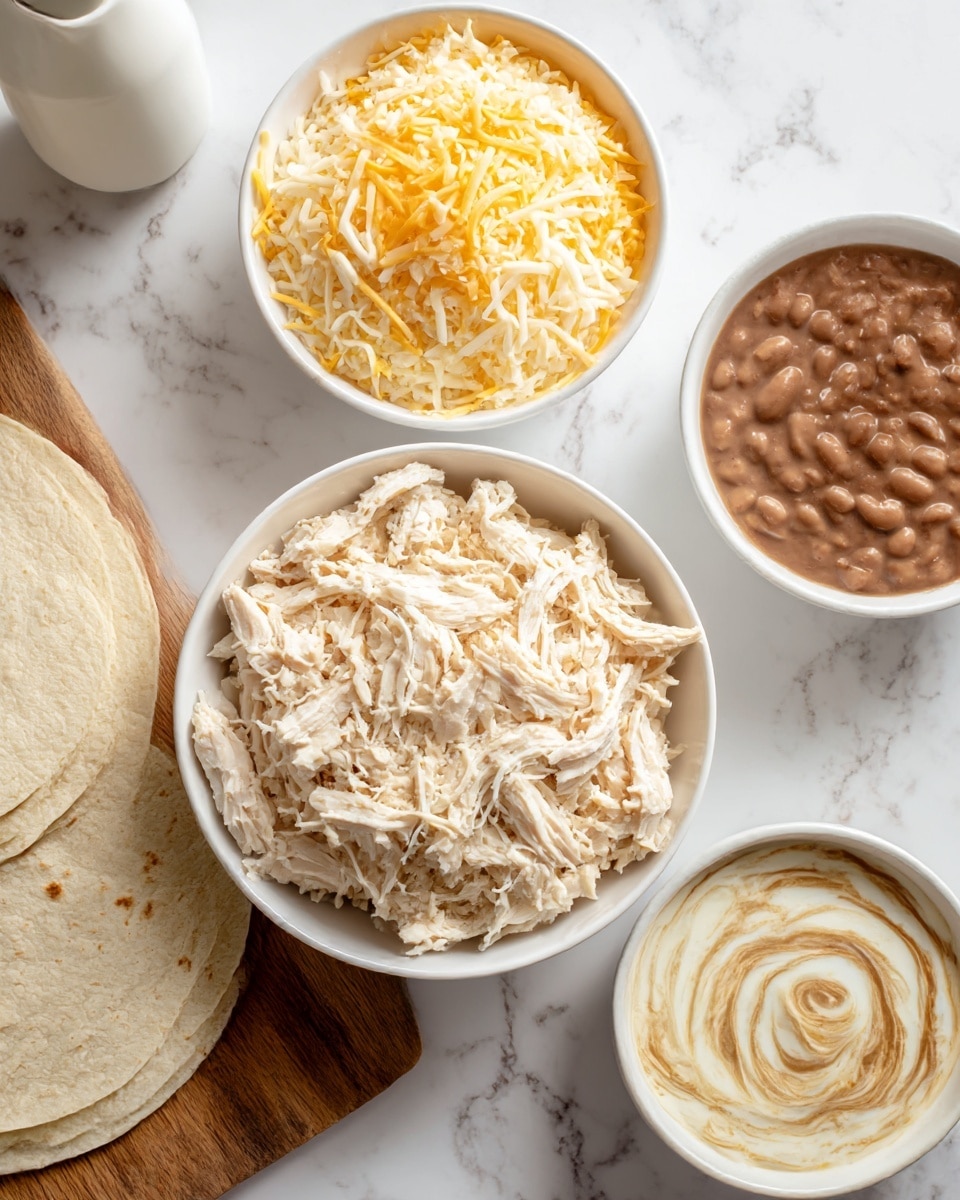 A white bowl filled with shredded cooked chicken sits on a white marbled surface, alongside a white bowl filled with a mix of shredded yellow and white cheese. Nearby, there is a stack of plain tortillas placed on a wooden cutting board, and a small white bowl containing refried beans with a swirl pattern on top. A white bottle with a spout is also visible on the side. photo taken with an iphone --ar 4:5 --v 7