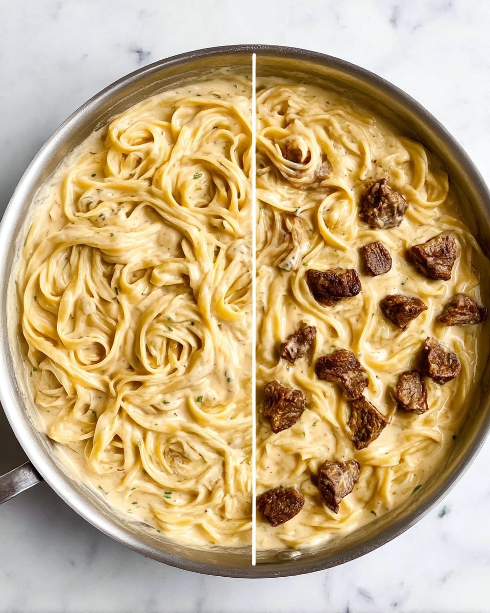 A round metal pan filled with creamy fettuccine pasta in a smooth, light beige sauce with specks of herbs. The pasta strands are visible and well coated, swirling gently across the pan. On the right half of the pan, small, dark brown pieces of cooked beef are scattered on top, contrasting with the pale sauce and pasta beneath. The pan sits on a white marbled surface. photo taken with an iphone --ar 4:5 --v 7