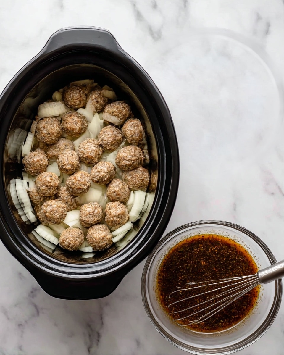 A black slow cooker filled with two layers: the bottom layer is a bed of white sliced onions arranged flat, and the top layer shows many small, round, lightly browned meatballs scattered over the onions. Next to it, a clear glass bowl contains a dark brown sauce with specks of herbs or spices, with a metal whisk resting at the bowl’s edge. Both items are placed on a white marbled surface. photo taken with an iphone --ar 4:5 --v 7