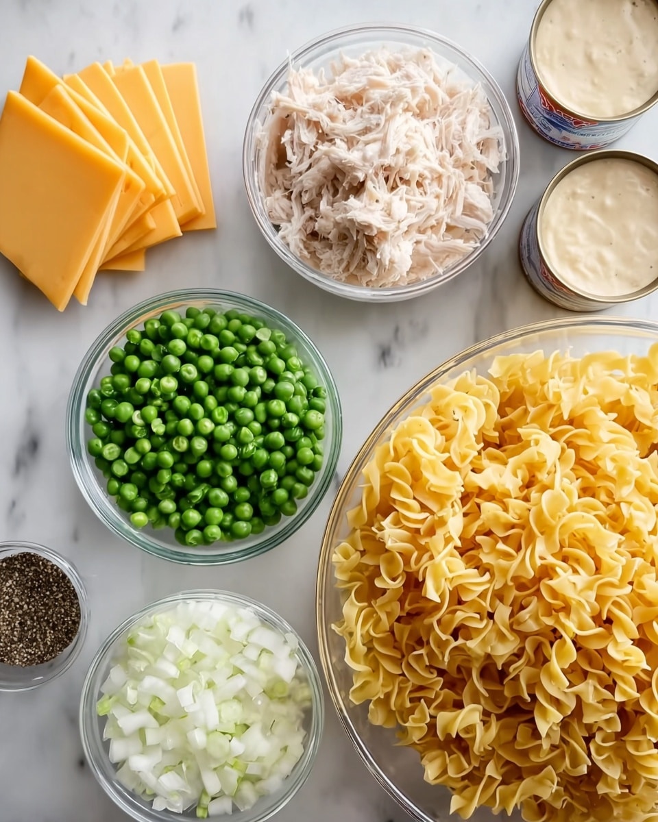 The image shows several clear glass bowls arranged on a white marbled surface, each holding different cooking ingredients. One large bowl on the right side is filled with yellow egg noodles, twisted and curly. Next to it on the left are smaller bowls containing frozen green peas, finely chopped white onions, and shredded light beige chicken. To the top left, there is a neat stack of square yellow cheese slices. Two small open cans with creamy soup mixtures are visible at the top right of the image. In the bottom left corner, a small clear container holds mixed black pepper. The overall view is bright with natural light coming from above. photo taken with an iphone --ar 4:5 --v 7