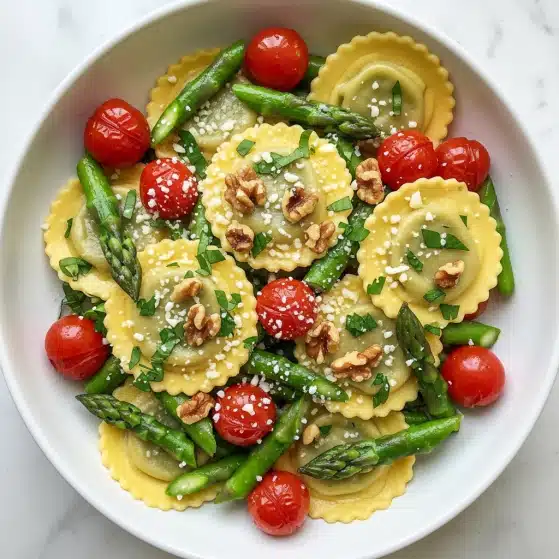 This image shows a dish with three main layers: the base layer is light yellow ravioli with crinkled edges, scattered throughout the dish. On top of this, there are bright green asparagus pieces, some whole and some cut, along with whole and halved roasted red cherry tomatoes that add vibrant color. The third layer has small brown walnut pieces sprinkled all over, along with small bits of fresh green herbs and a light dusting of white grated cheese. The food is placed in a white bowl on a white marbled surface. photo taken with an iphone --ar 4:5 --v 7