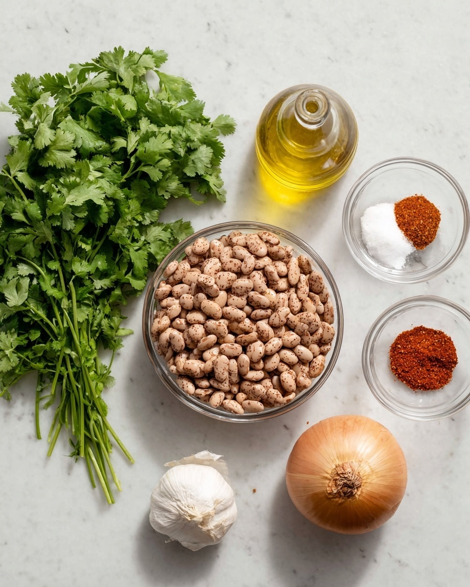 The image shows ingredients arranged on a white marbled surface: a large bunch of green cilantro leaves with stems on the left, a small glass bottle filled with light golden olive oil above it, a clear glass bowl filled with tan and brown speckled pinto beans in the center, a small clear bowl containing two halves of white salt and red chili powder on the top right, two peeled garlic cloves slightly below the small bowl, and a whole yellow onion with brown skin on the bottom right. Photo taken with an iphone --ar 4:5 --v 7