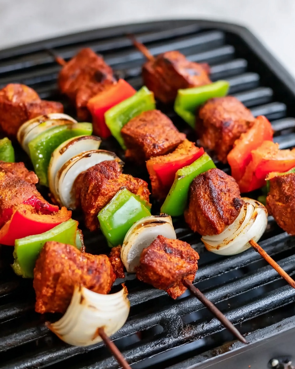 Three wooden skewers with grilled meat pieces, red bell pepper slices, green bell pepper slices, white onion pieces, and some more red bell pepper are placed on a black grill grate. The meat is seasoned and has a reddish brown color. The vegetables are fresh and bright, with shiny textures on the grill. A white marbled surface can be seen faintly behind the grill photo taken with an iphone --ar 4:5 --v 7