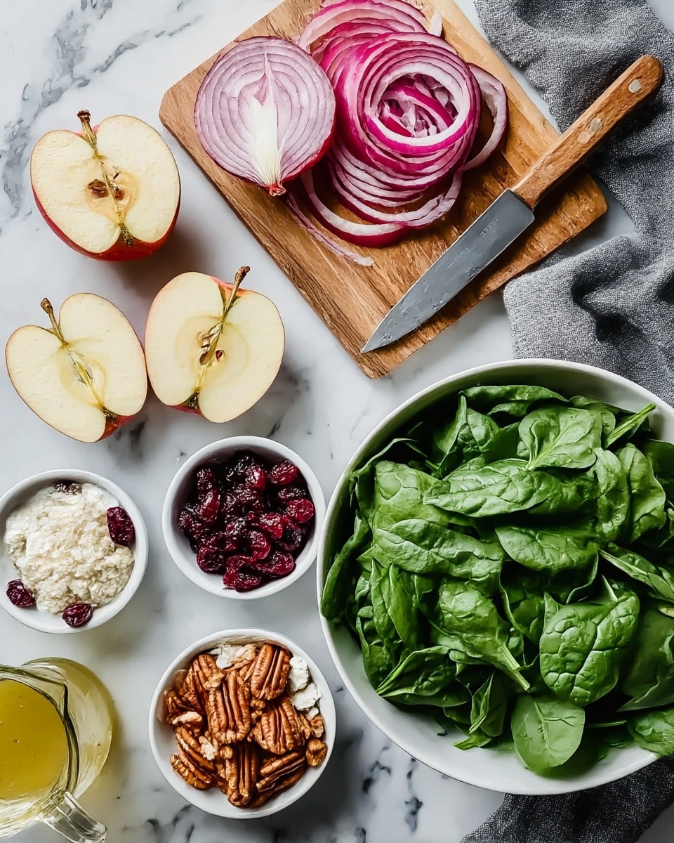 The image shows fresh ingredients arranged on a white marbled surface. There is a large white bowl filled with bright green spinach leaves on the bottom right, next to a gray cloth. Above it is a wooden cutting board with thinly sliced red onion rings and a knife with a wooden handle. To the left, there is a whole red onion and two apple halves showing their light yellow interior and seeds. Below the apples are three small white bowls containing dark red dried cranberries, brown pecans, and white crumbled cheese. At the bottom left corner, there is a small glass container with light yellow dressing. Photo taken with an iphone --ar 4:5 --v 7