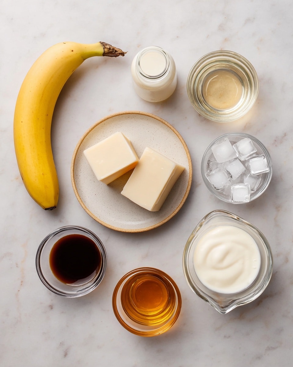 The image shows several ingredients neatly arranged on a white marbled surface. On the left, there is a whole yellow banana placed diagonally. Below it, three pale beige blocks are stacked on a small white plate with a light brown rim. Around these, six small clear glass containers hold different liquids and items: a milky white liquid in a small bottle near the top center, a light transparent cream liquid in a small bowl below it, dark brown liquid in a bowl to the right, a smaller bowl with white cream below that, amber-colored liquid in a small pitcher at the bottom right, and a bowl of clear ice cubes at the top right. All items are placed separately with clear space between them. Photo taken with an iphone --ar 4:5 --v 7