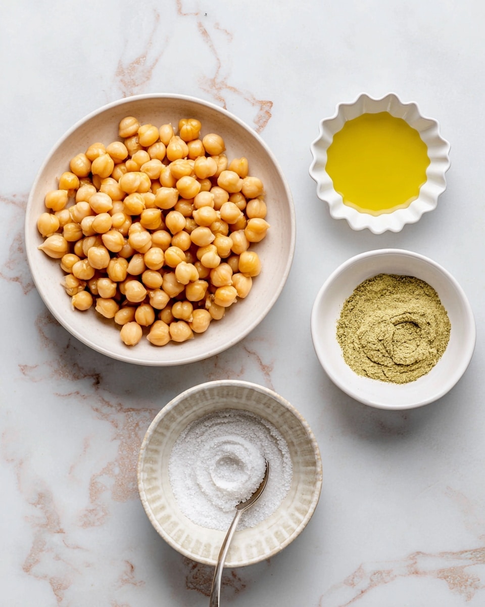 The image shows four white dishes placed on a white marbled surface. The largest dish in the center contains a single layer of light orange canned chickpeas with a smooth texture and round shape. To the top right, there is a small white scalloped bowl filled with a thin, golden yellow liquid labeled avocado oil. Below this, to the right, is another white bowl containing a light green seasoning powder with a powdery texture and a small spoon resting inside. At the bottom center, a small white bowl holds a layer of fine white salt with a slight spiral pattern on top. photo taken with an iphone --ar 4:5 --v 7