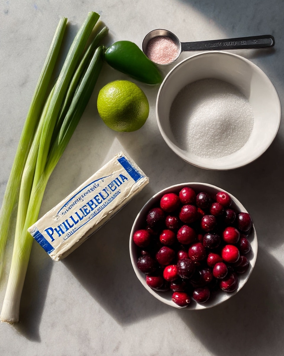 On a white marbled surface, there is a white bowl full of bright red and dark red cranberries on the bottom right. Above the bowl, there is a white bowl filled with white sugar and a metal measuring spoon with light pink salt on it resting across the top edge. To the left, a fresh green jalapeño and a whole green lime sit close to a rectangular block of Philadelphia original cream cheese with blue and white packaging lying flat. On the far left, two long green spring onions with white ends stretch diagonally from the bottom left toward the top left. The lighting is soft and natural showing clear detail on all items photo taken with an iphone --ar 4:5 --v 7