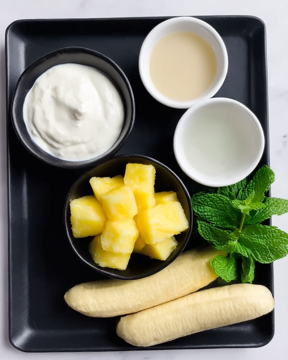 A black rectangular tray on top of a white marbled surface holds four items. On the top left, there is a small black bowl filled with thick white cream with a smooth texture. To its right, a small white bowl contains light beige liquid. Below the cream, a black bowl is filled with bright yellow pineapple chunks that look juicy and fresh. On the bottom right of the tray, two pale yellow peeled bananas lay side by side. At the top right corner of the tray, a small bunch of fresh green mint leaves adds color contrast. Photo taken with an iphone --ar 4:5 --v 7