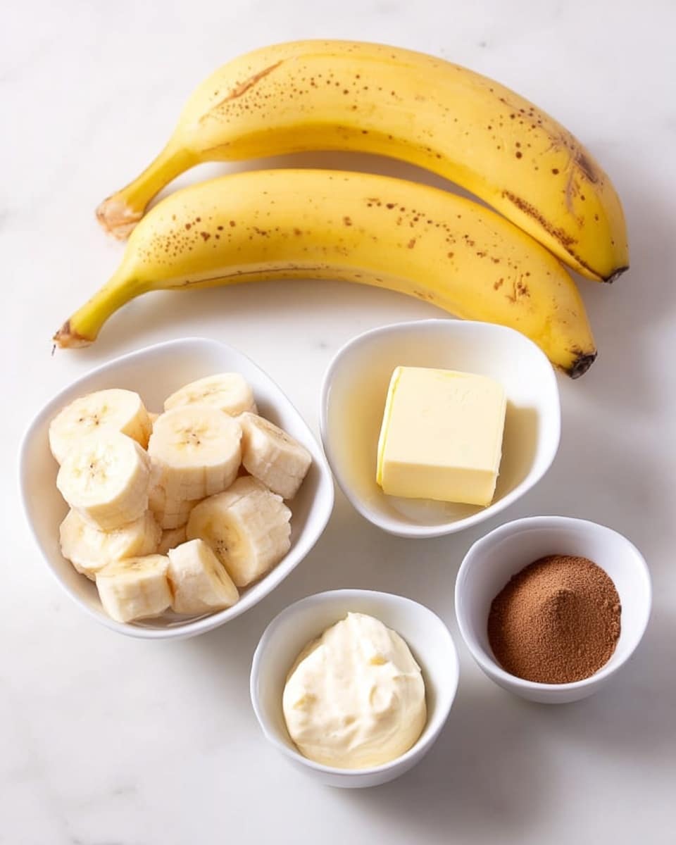 The image shows two whole yellow bananas with small brown spots placed on a white marbled surface. To the right are four small white bowls; the largest bowl holds many banana slices, the smallest bowl has a light cream-colored creamy substance, the medium bowl contains a block of yellow butter, and the last bowl holds a heap of brown powder. Everything is arranged neatly with soft light highlighting the smooth textures of the bananas and bowls, photo taken with an iphone --ar 4:5 --v 7