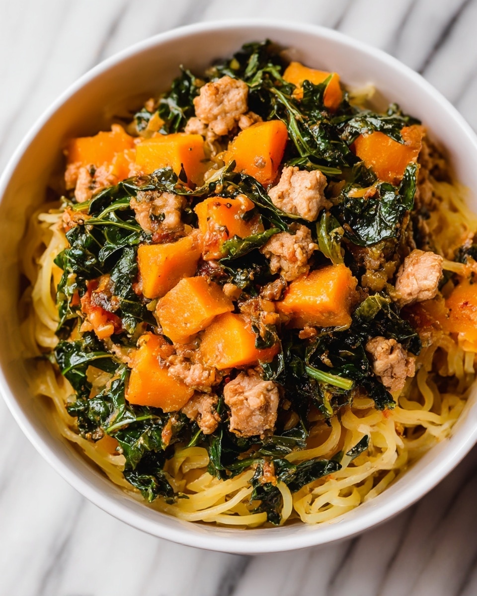 A white bowl is filled with a colorful mix of food on a white marbled surface. At the bottom, there are soft looking, light yellow noodles forming the base layer. On top of the noodles, there are bright orange chunks of cooked squash or sweet potato. Scattered among the orange pieces are small light brown chunks and crumbled pieces of cooked meat. Mixed throughout and layered over these ingredients are vibrant dark green leafy vegetables that appear tender and slightly wilted. The dish has a textured and hearty look with all components closely packed in the bowl. Photo taken with an iphone --ar 4:5 --v 7