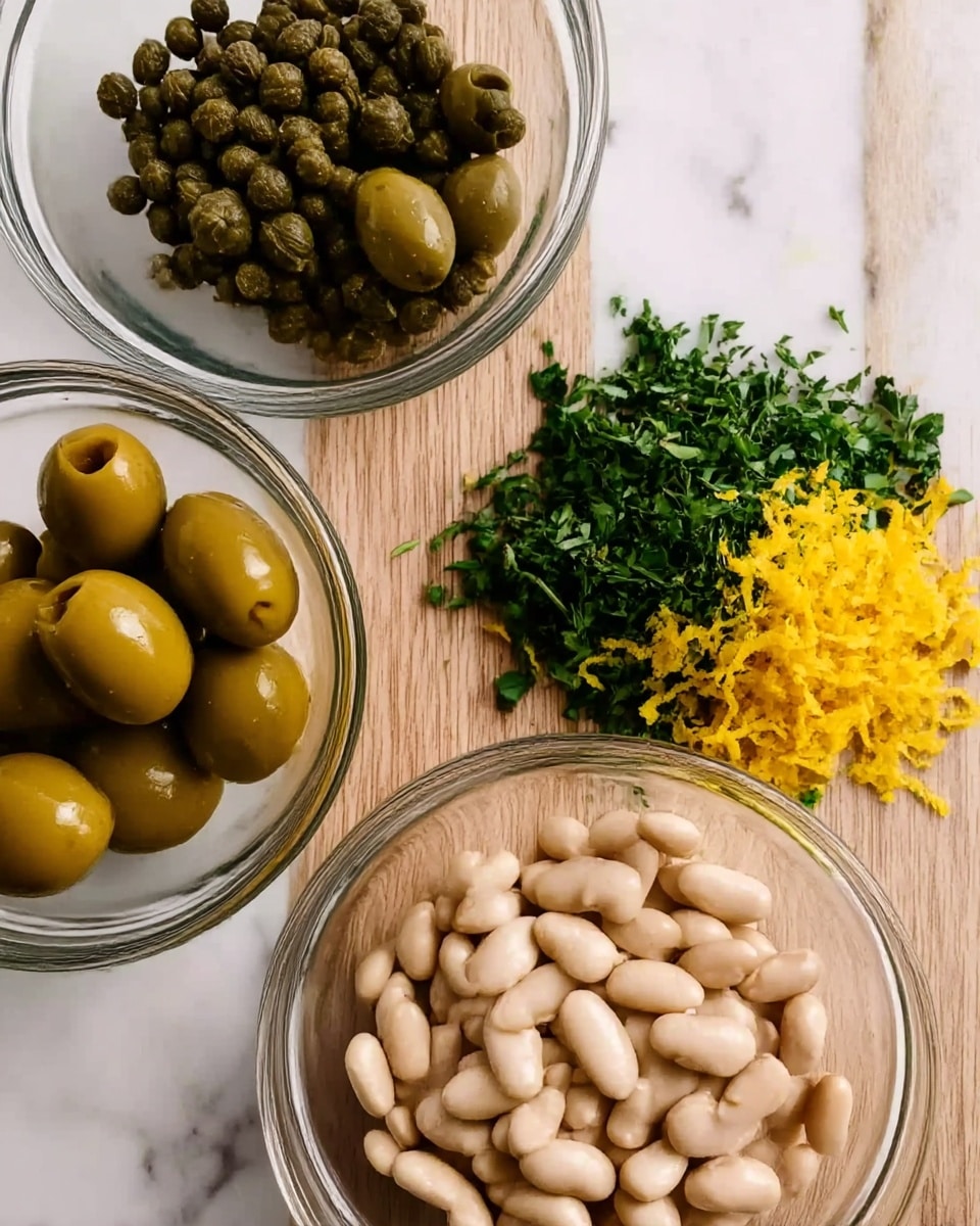 The image shows three clear glass bowls on a white marbled surface. The first bowl at the top left holds small capers that are dark green and round. The second bowl at the bottom left contains large pitted green olives with a shiny texture. The third bowl at the bottom center is filled with white beans that have a smooth texture. In the middle of the image, there is a small pile of finely chopped green herbs and bright yellow lemon zest, both placed directly on the white marbled surface. The wood board beneath the herbs and zest is visible with its natural brown grain. Photo taken with an iphone --ar 4:5 --v 7