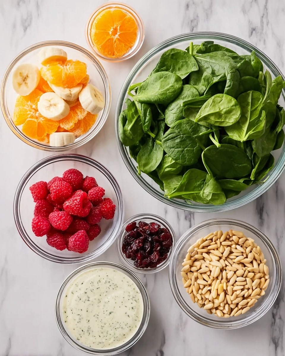The image shows seven clear glass bowls arranged on a white marbled surface. The largest bowl is filled with fresh green spinach leaves, positioned on the right side. Around it are six smaller bowls: one at the top left contains bright orange mandarin segments, below it a bowl with banana slices, next to it a bowl with dried cranberries, and in the center top a bowl filled with red sliced strawberries. On the top right is a bowl with light beige pine nuts, and a bowl with creamy white dressing speckled with herbs is placed below the dried cranberries bowl. The bowls are neatly spaced, showing a clean arrangement. Photo taken with an iphone --ar 4:5 --v 7